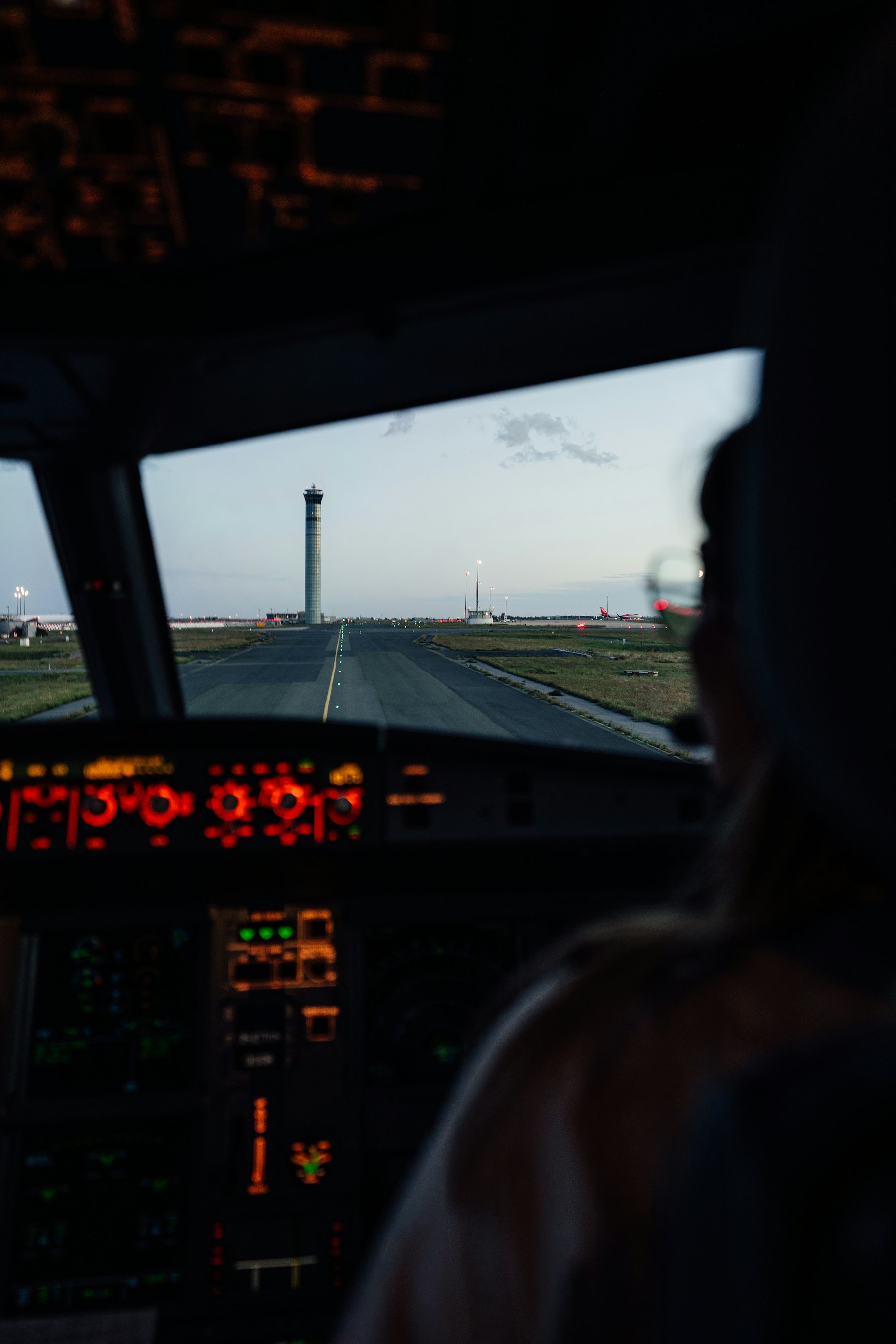 Jet cockpit at dusk facing a lit runway