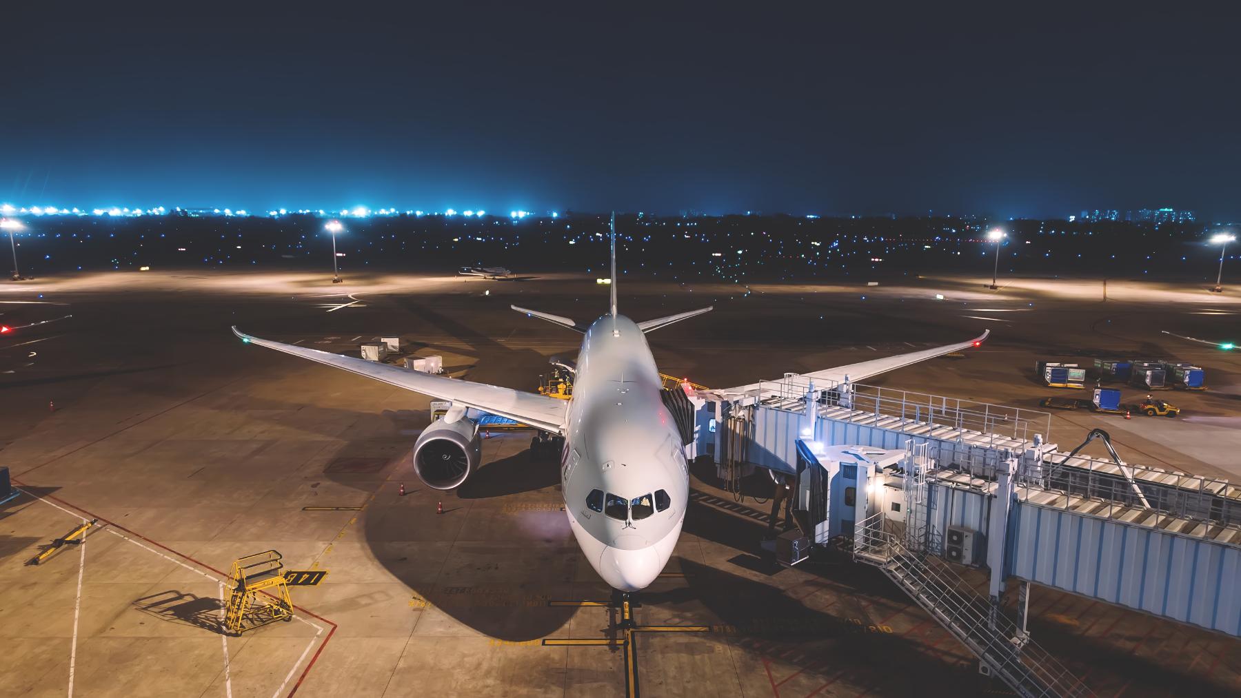 Widebody jet parked at a night gate during turnaround